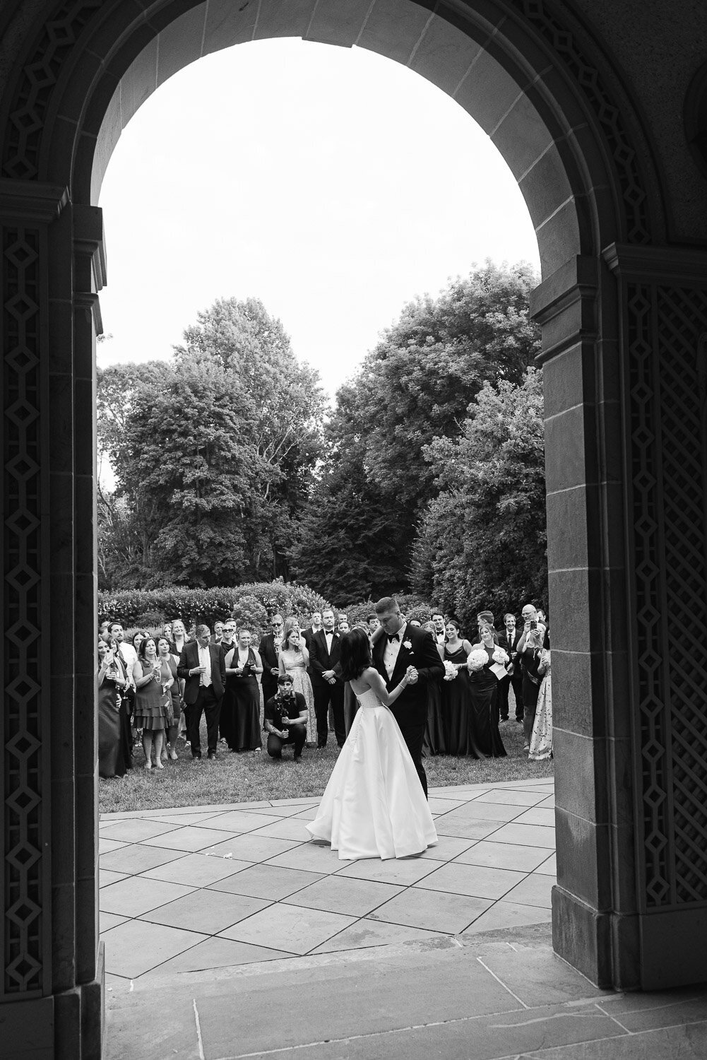 bride and groom dance outside on patio in archway