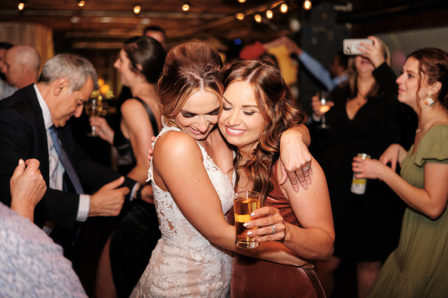 Bride hugs her sister on the dance floor