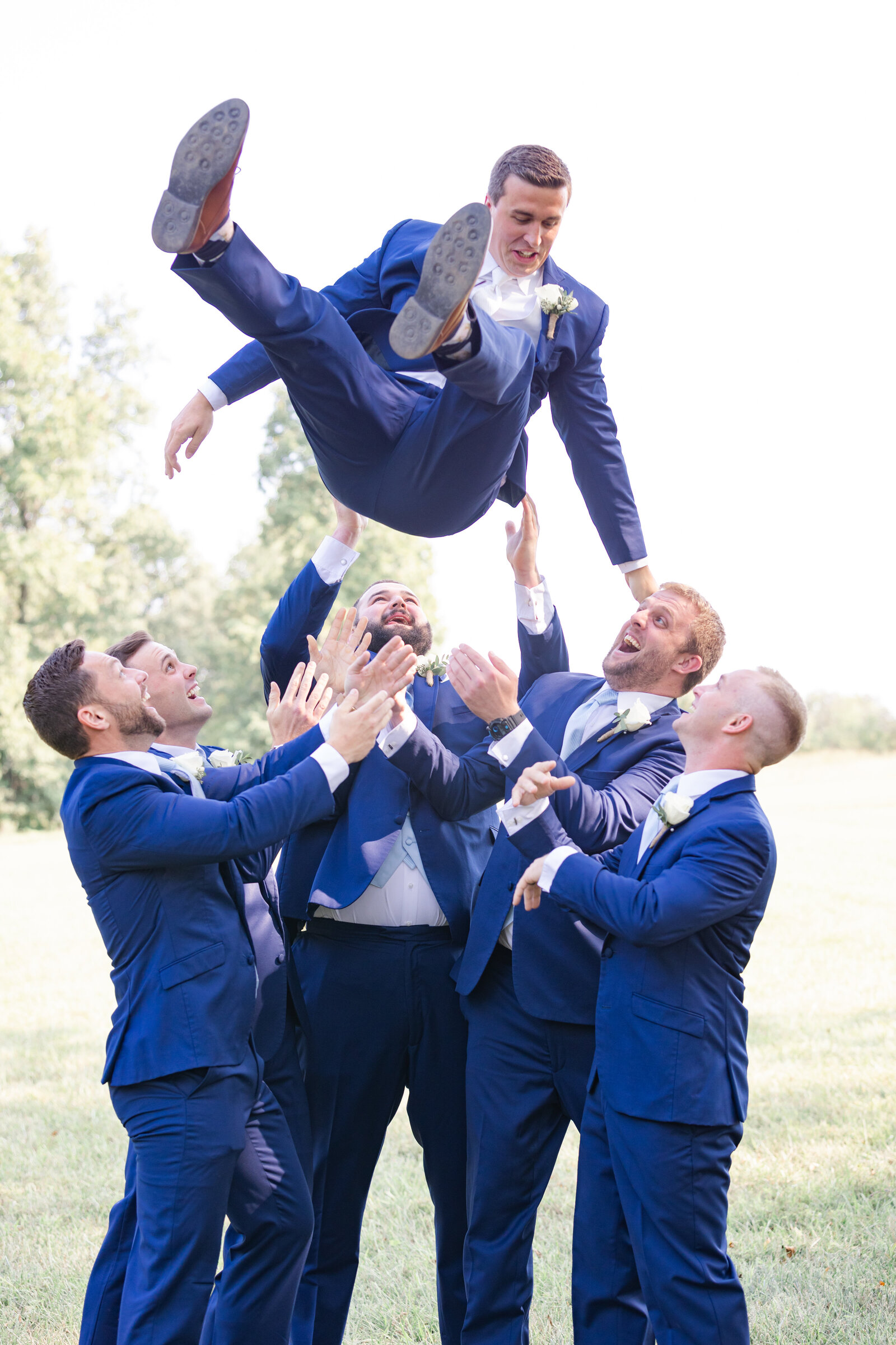 bright light and airy wedding photo of groom and groomsmen