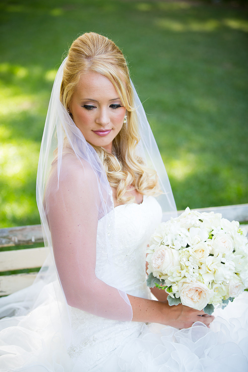 bride looking down with white bouquet