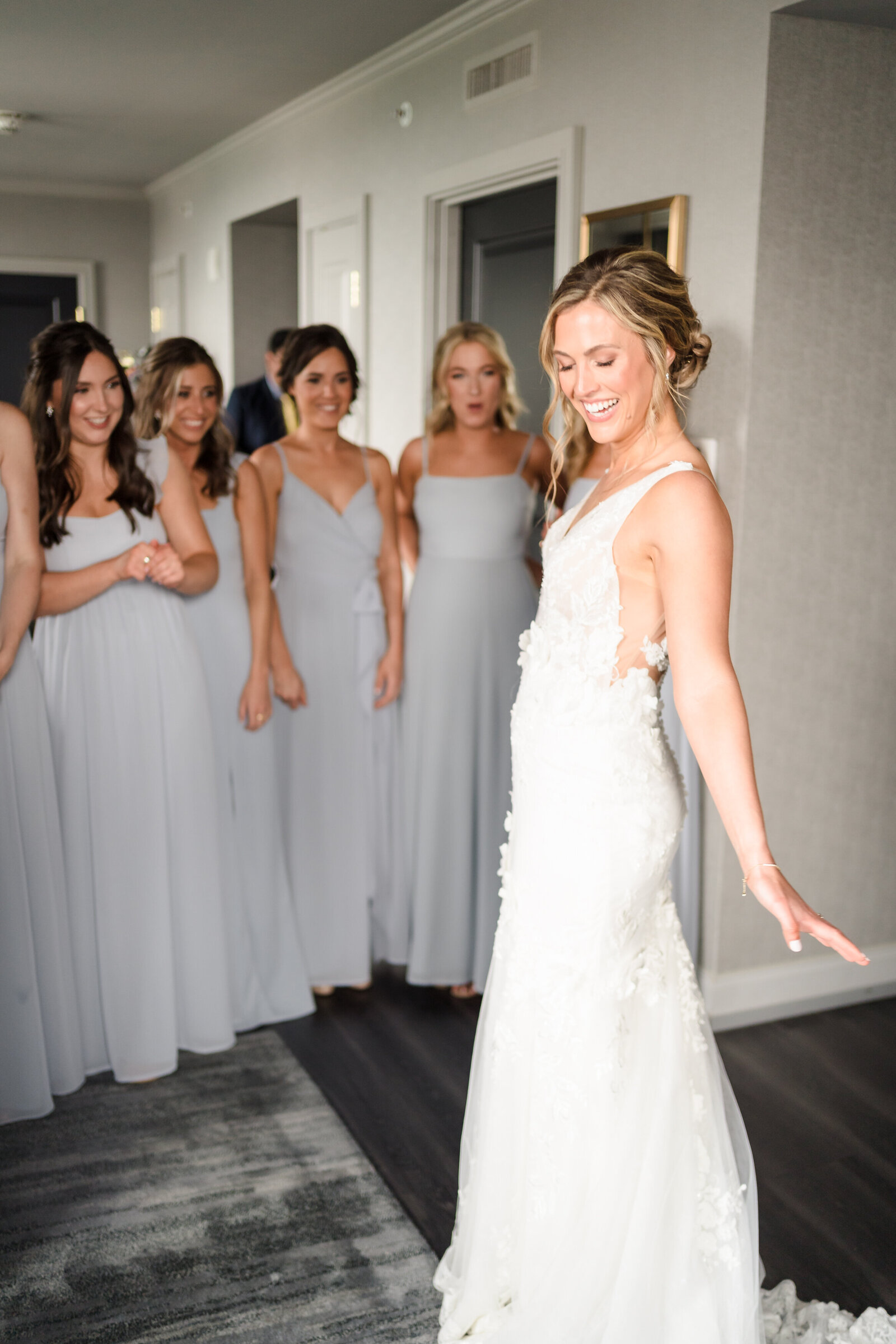 A bride shows off her wedding dress to her bridesmaids inside the suit at the LeVeque Tower