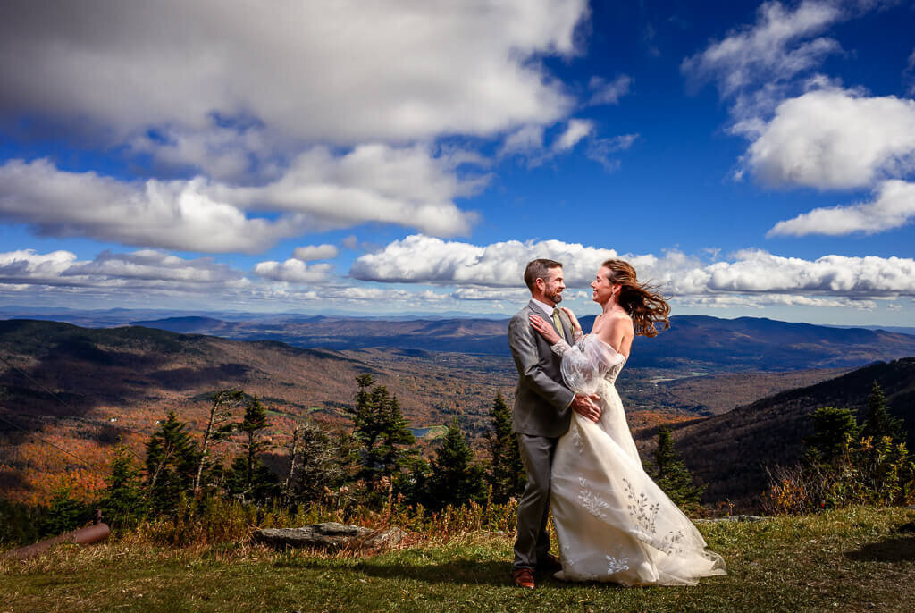A wedding portrait of a couple on top of Mt. Mansfield in Stowe, Vermont, during the fall foliage season at their Spruce Peak wedding, captured by Eaton Photo