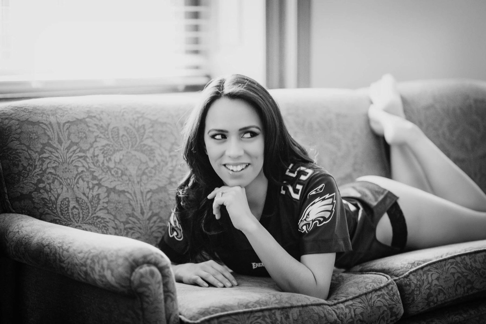 Ms C wears an Eagles jersey while laying on sofa, Boudoir Photography, Charleston, SC