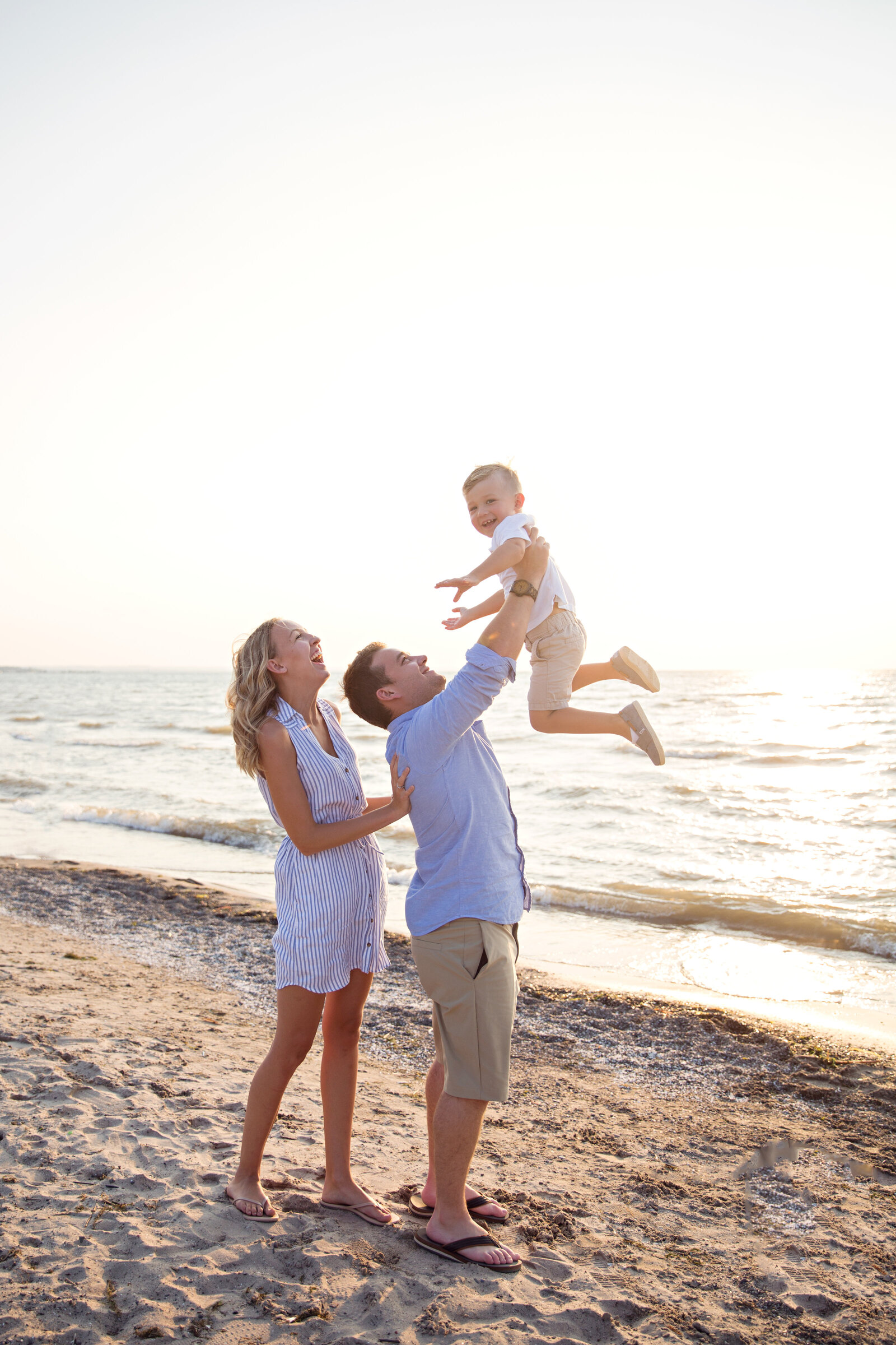 family with little boy at beach at sunset