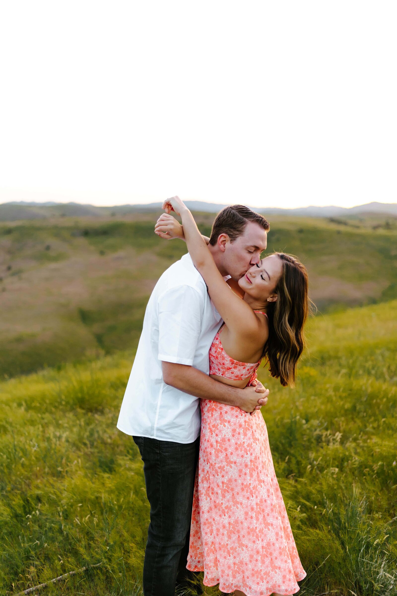 A couple embracing each other during their engagement photos in the hills above Boise, Idaho