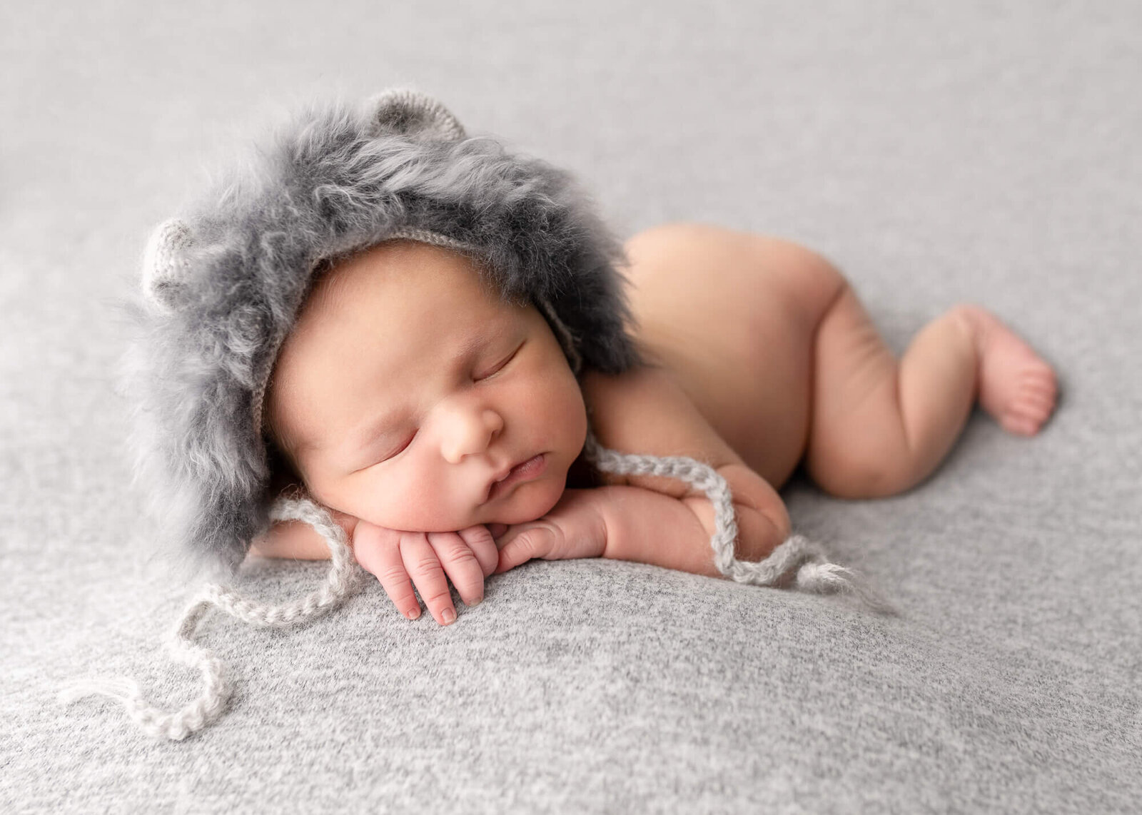 picture of baby on grey with wolf bonnet