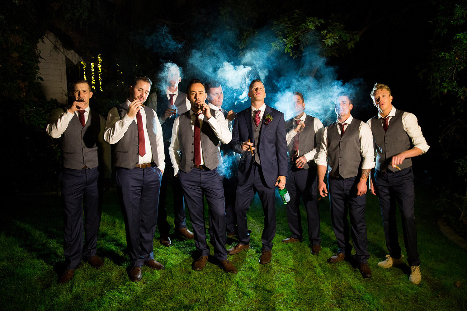 Male model groomsmen portrait with cigars at night