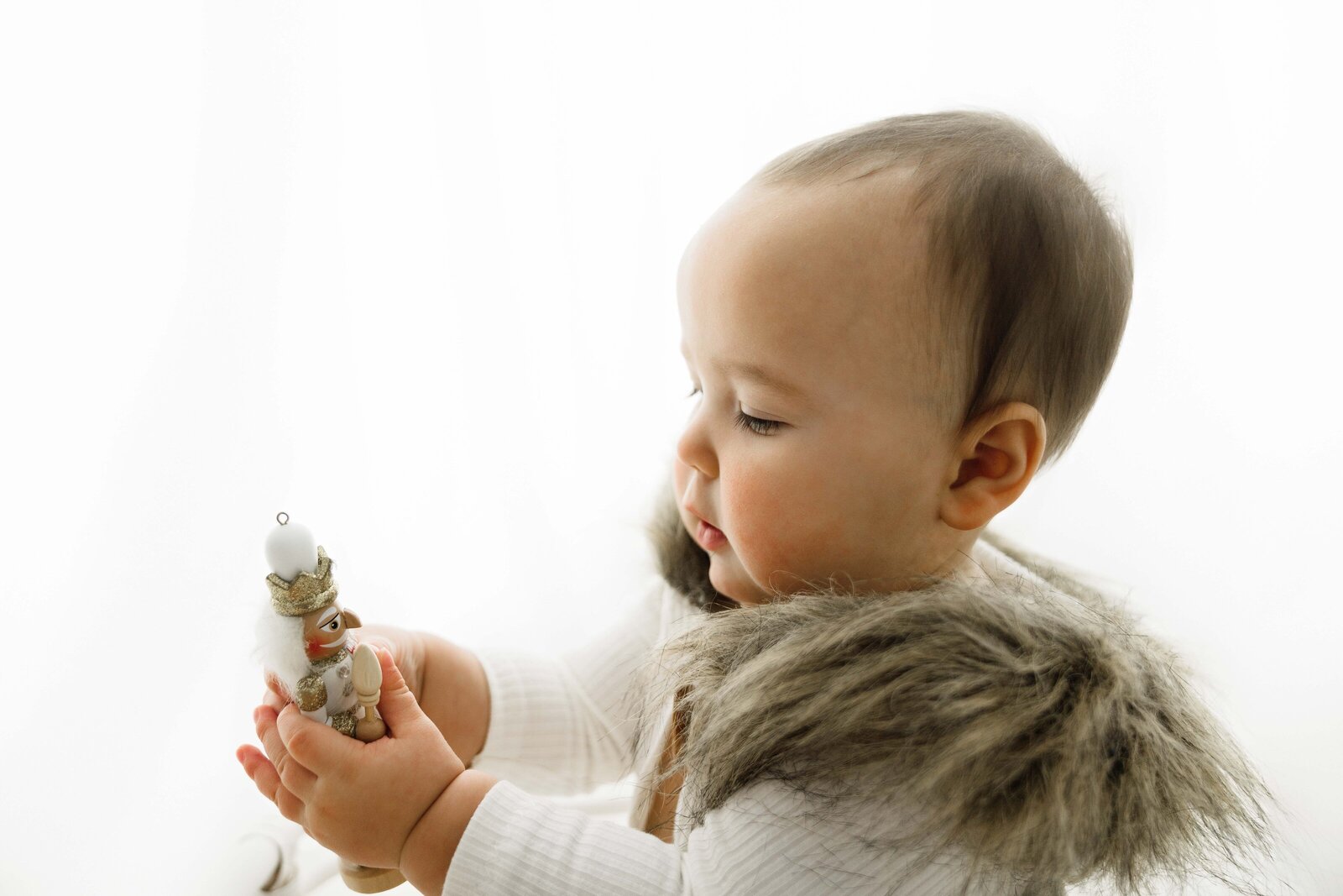 baby looking at wooden nutcracker