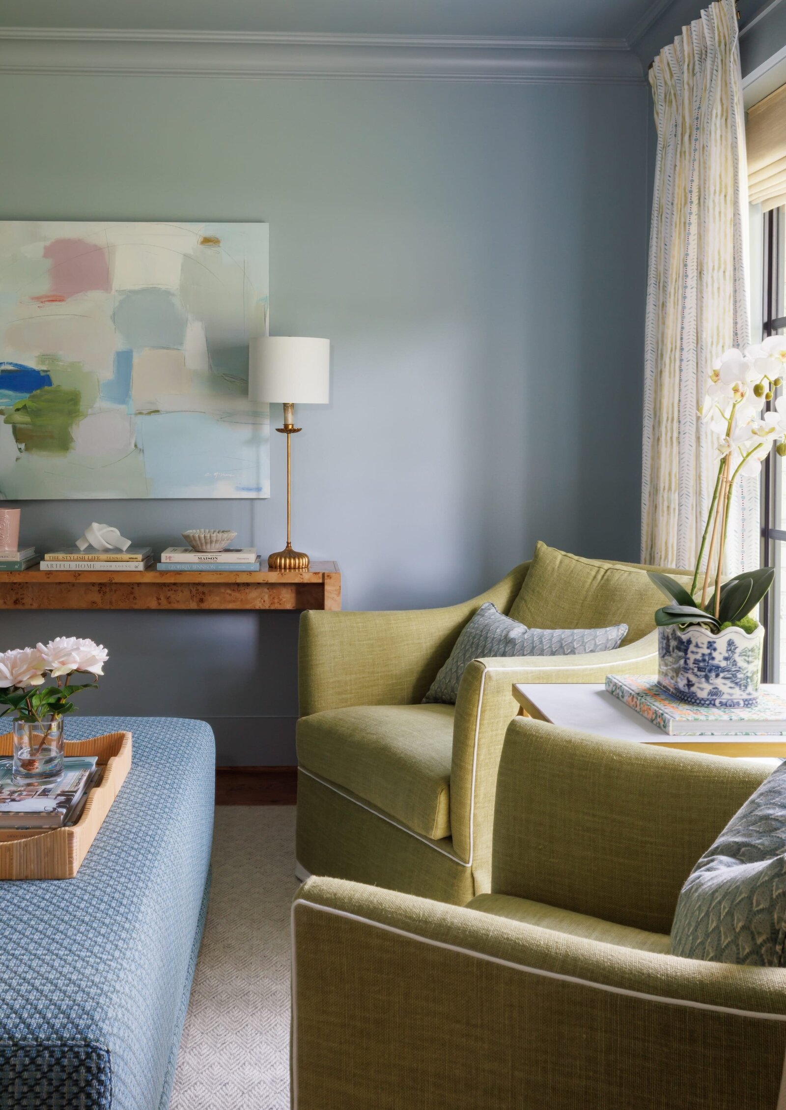 vision and hammer interior design sitting area with green chairs and blue fabric coffee table