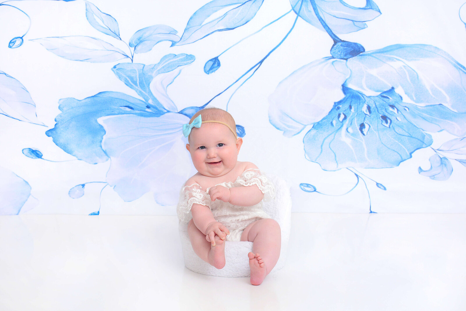 girl smiles at her floral half birthday photoshoot