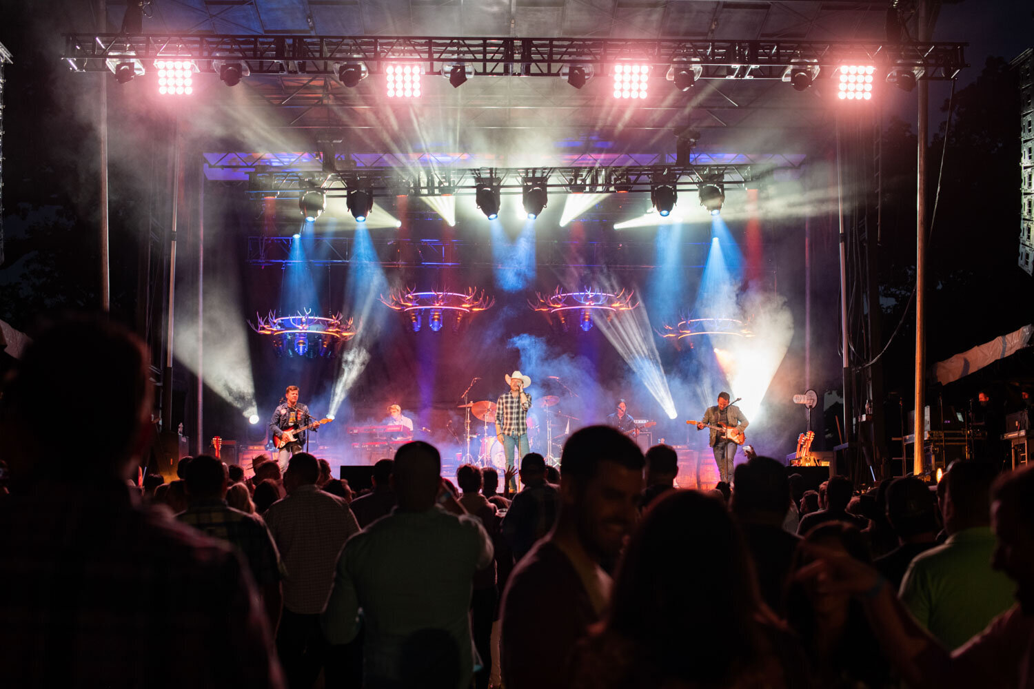Live concert with bright stage lights and a large audience