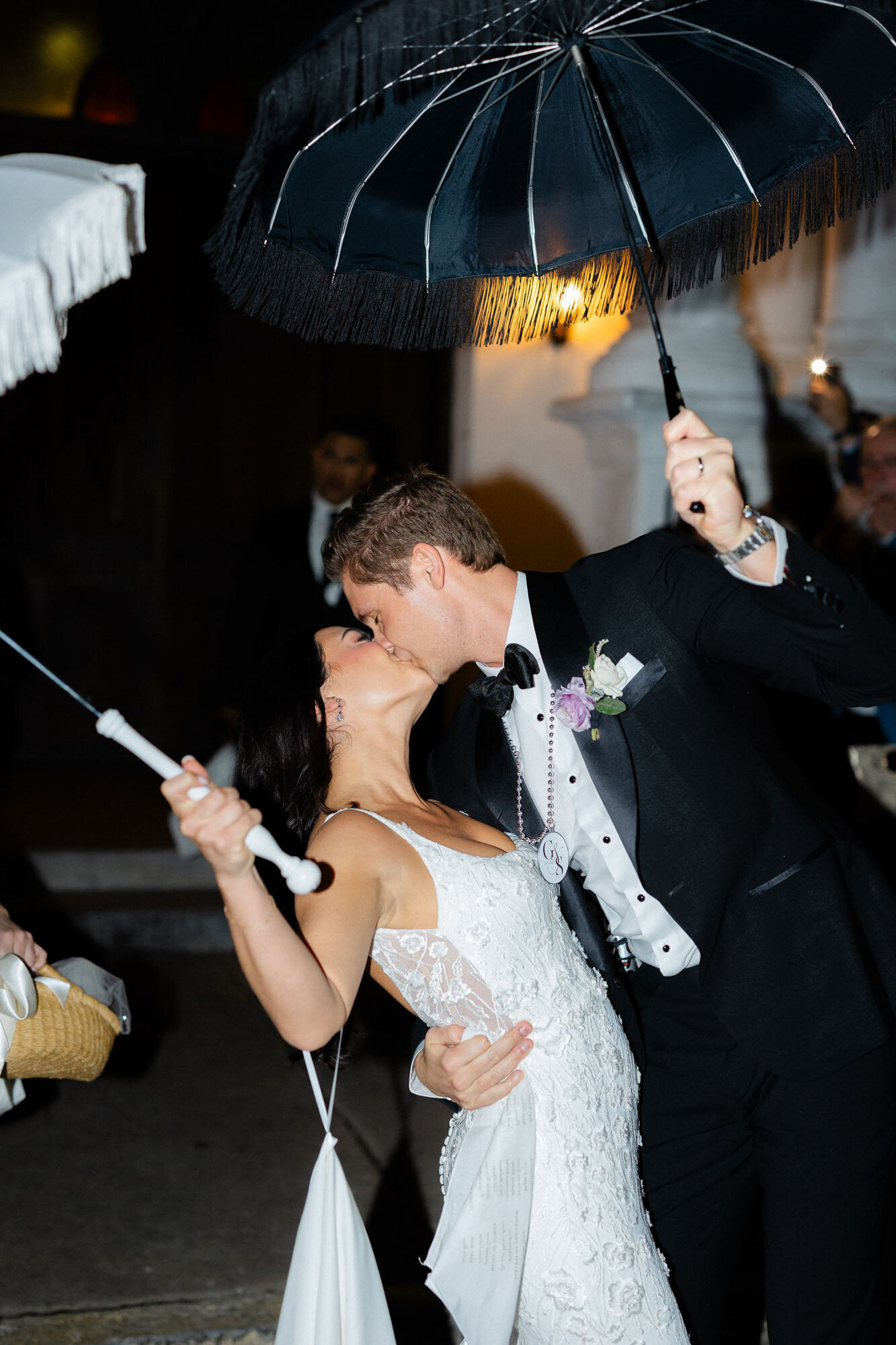 bride and groom standing with umbrellas