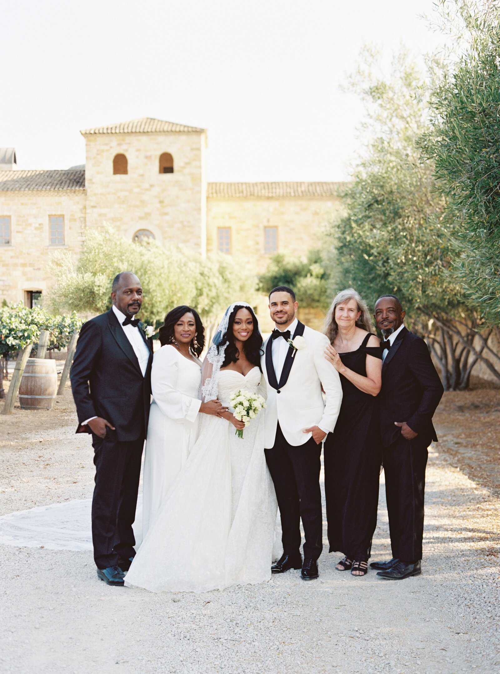 bride and groom standing with their parents