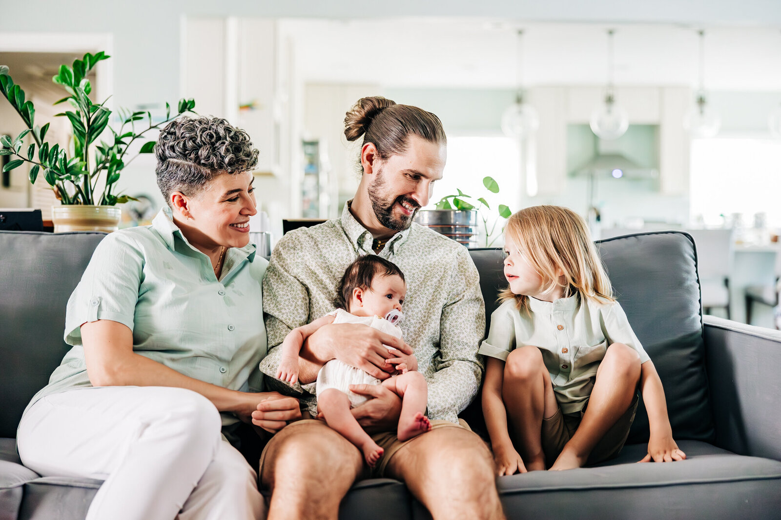 Relaxed family of four on the couch in thier home in st. pete fl