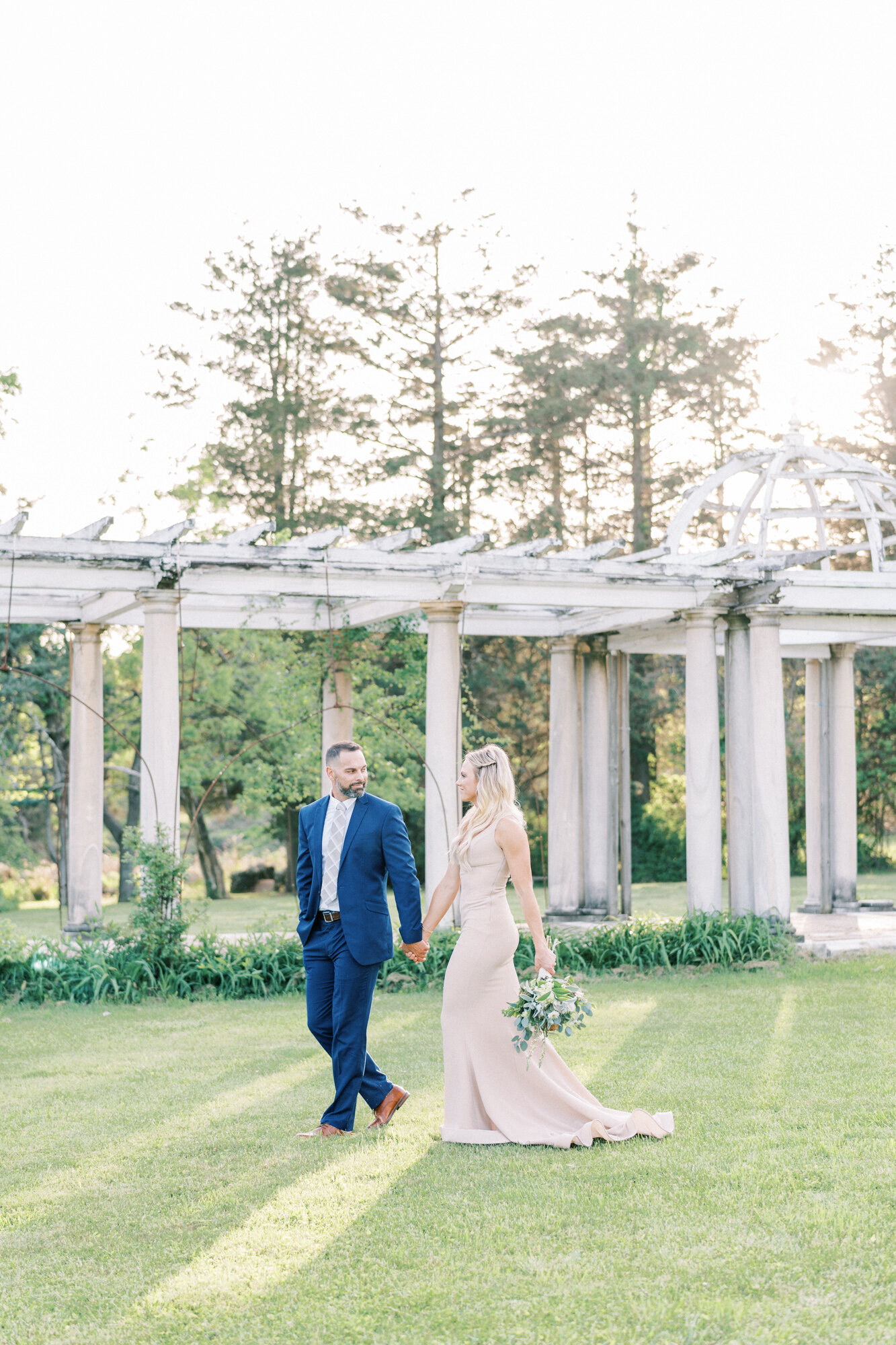 Bride and groom walk hand in hand at Swannanoa Palace