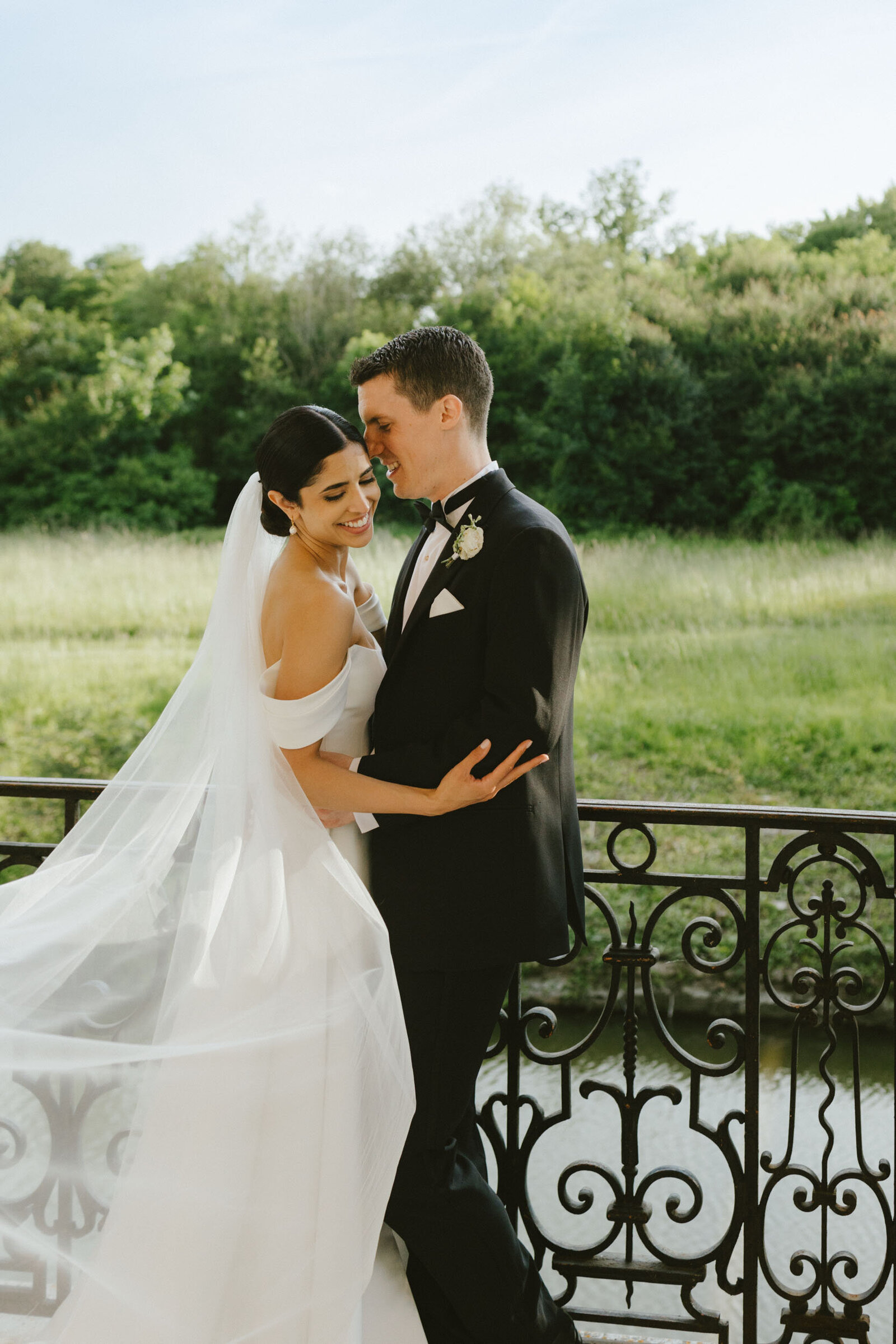 A bride and groom embrace and smile during a French countryside wedding at a chateau outside of Paris.