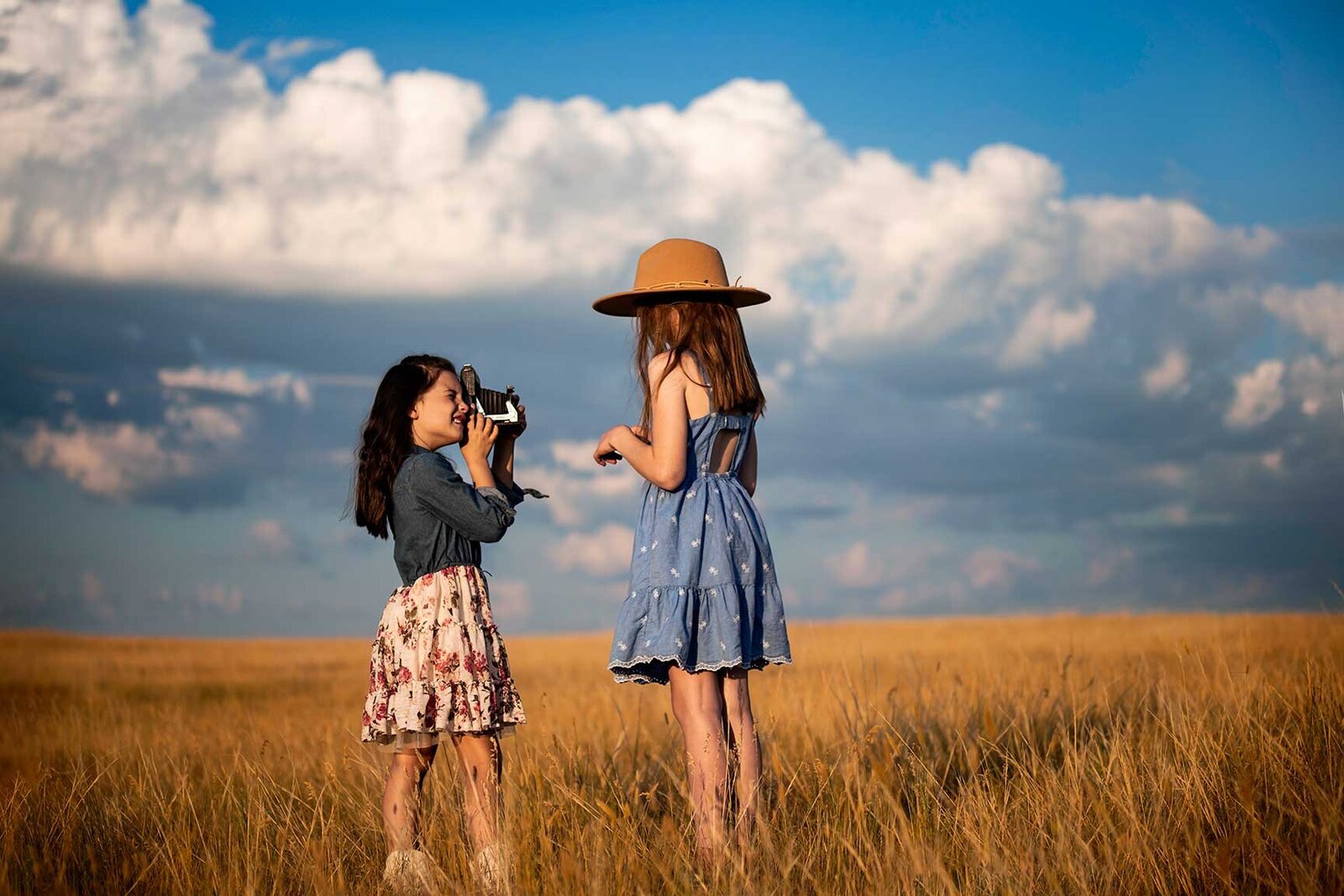 country-girls-photographing-in-field-blue-sky-vintage-camera-sisters-timeless-unique