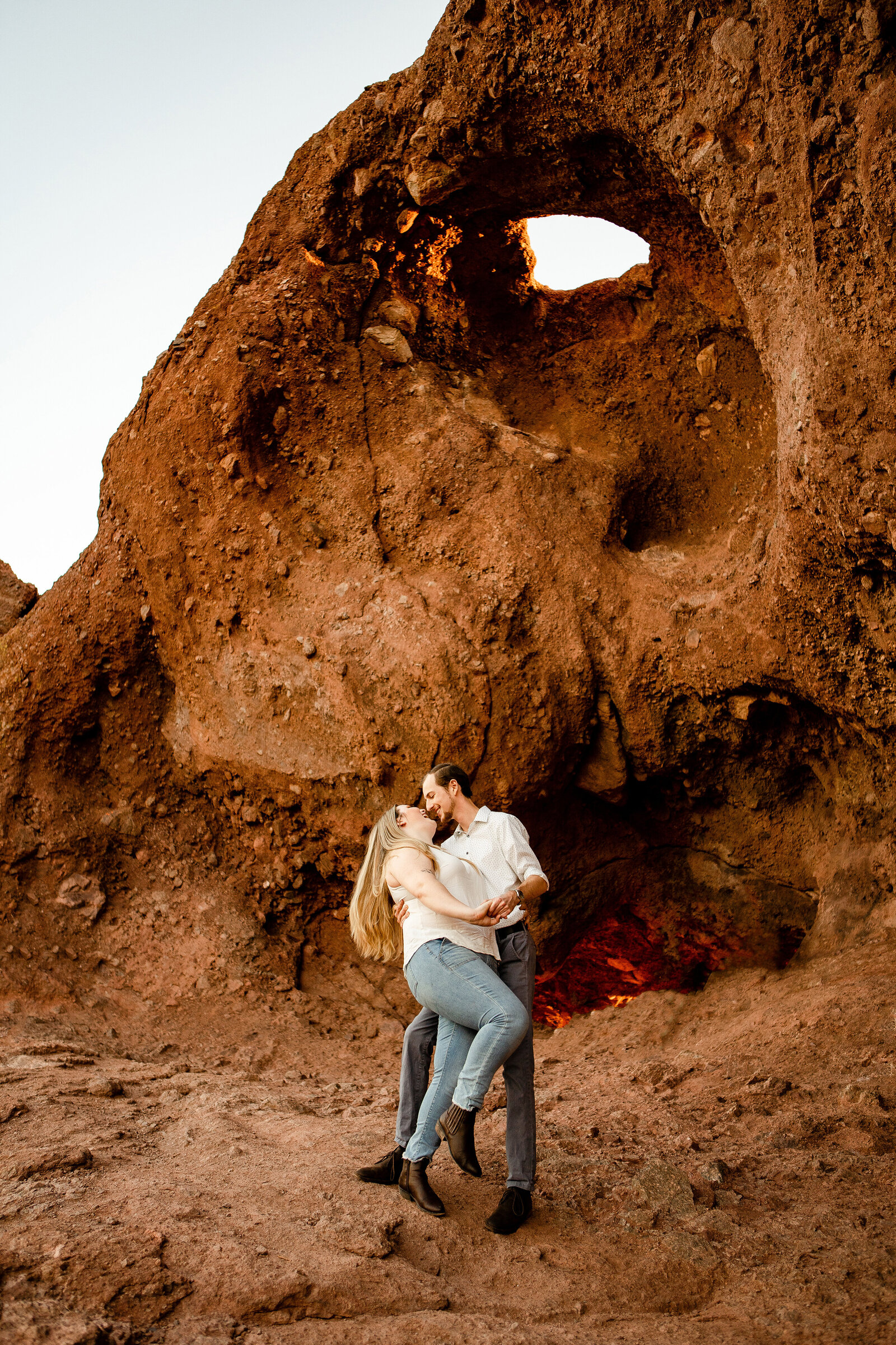 Papago Park engagement photo shoot in Phoenix, Arizona couple kissing under rocks