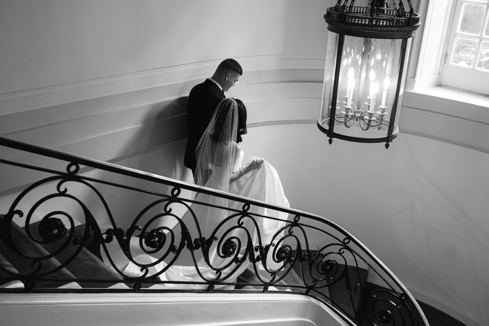 bride and groom walk down staircase from behind