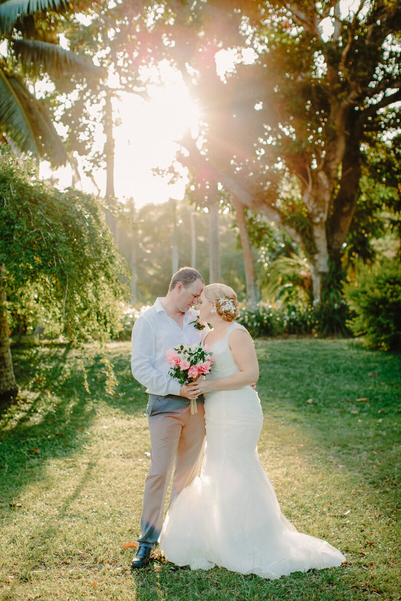 bridal couple with sun behind and palm trees