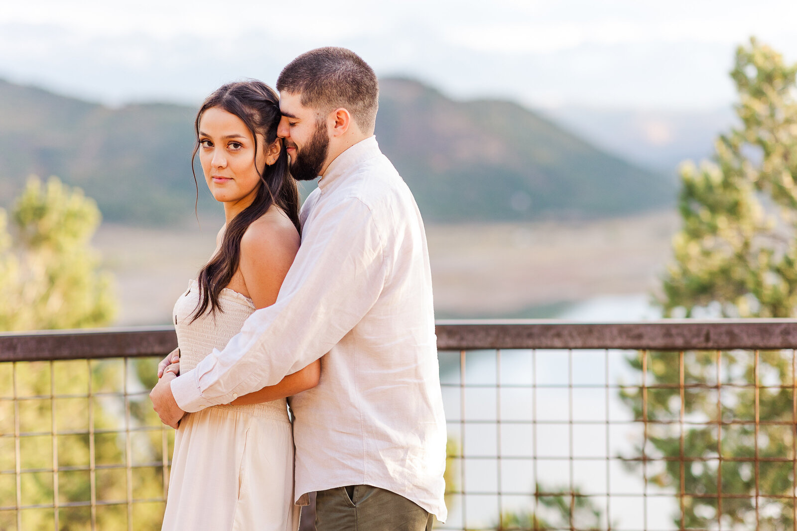 Couple wears beige clothing and poses for picture