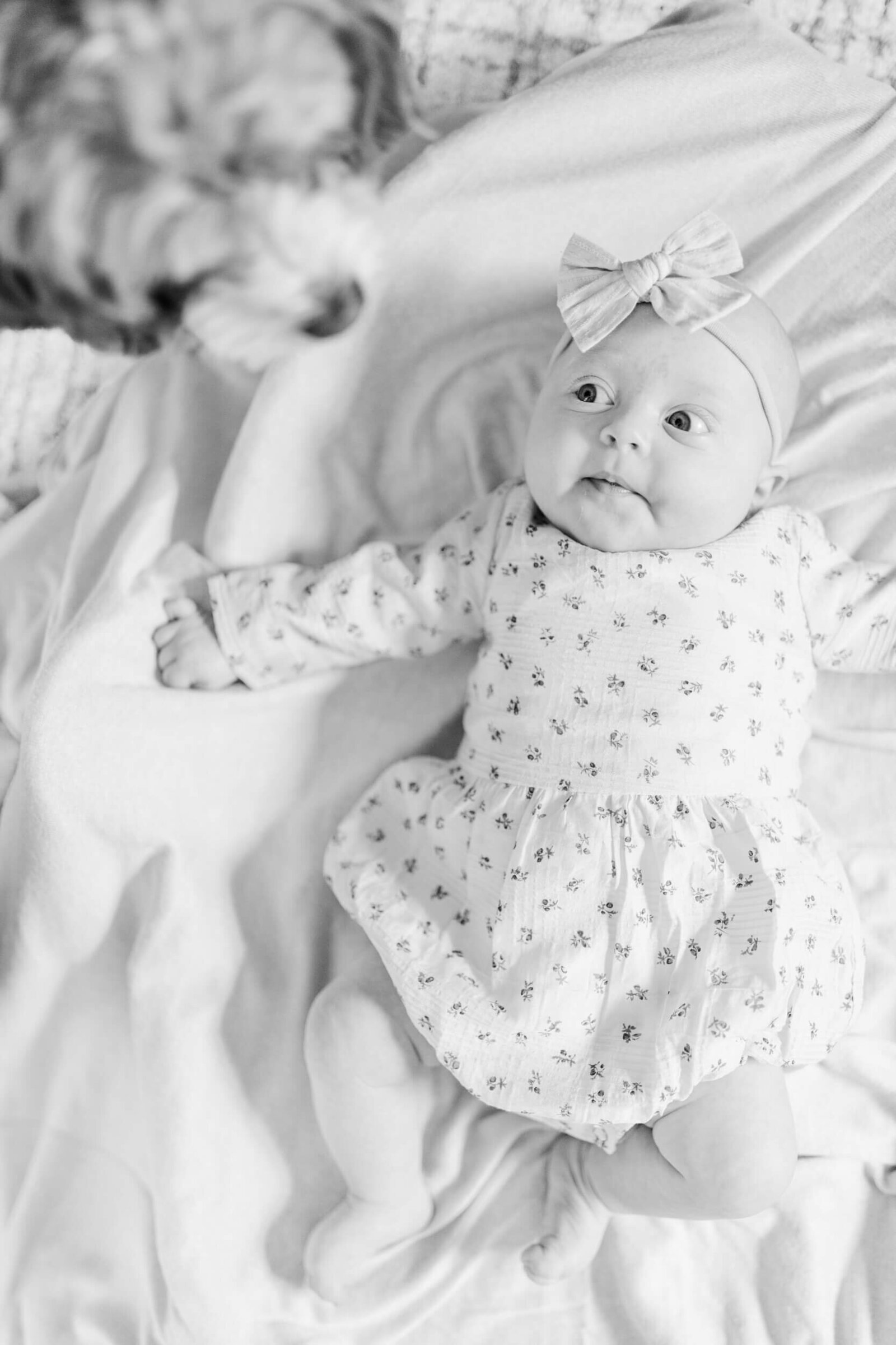 Baby laying on the floor looks at the family dog