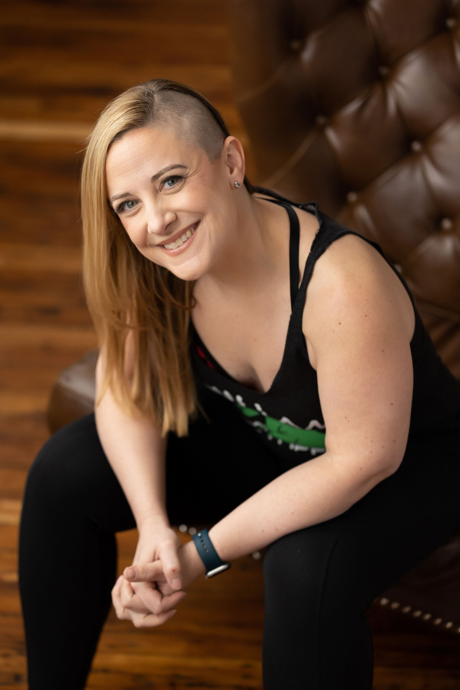 fit woman smiling and sitting on a couch
