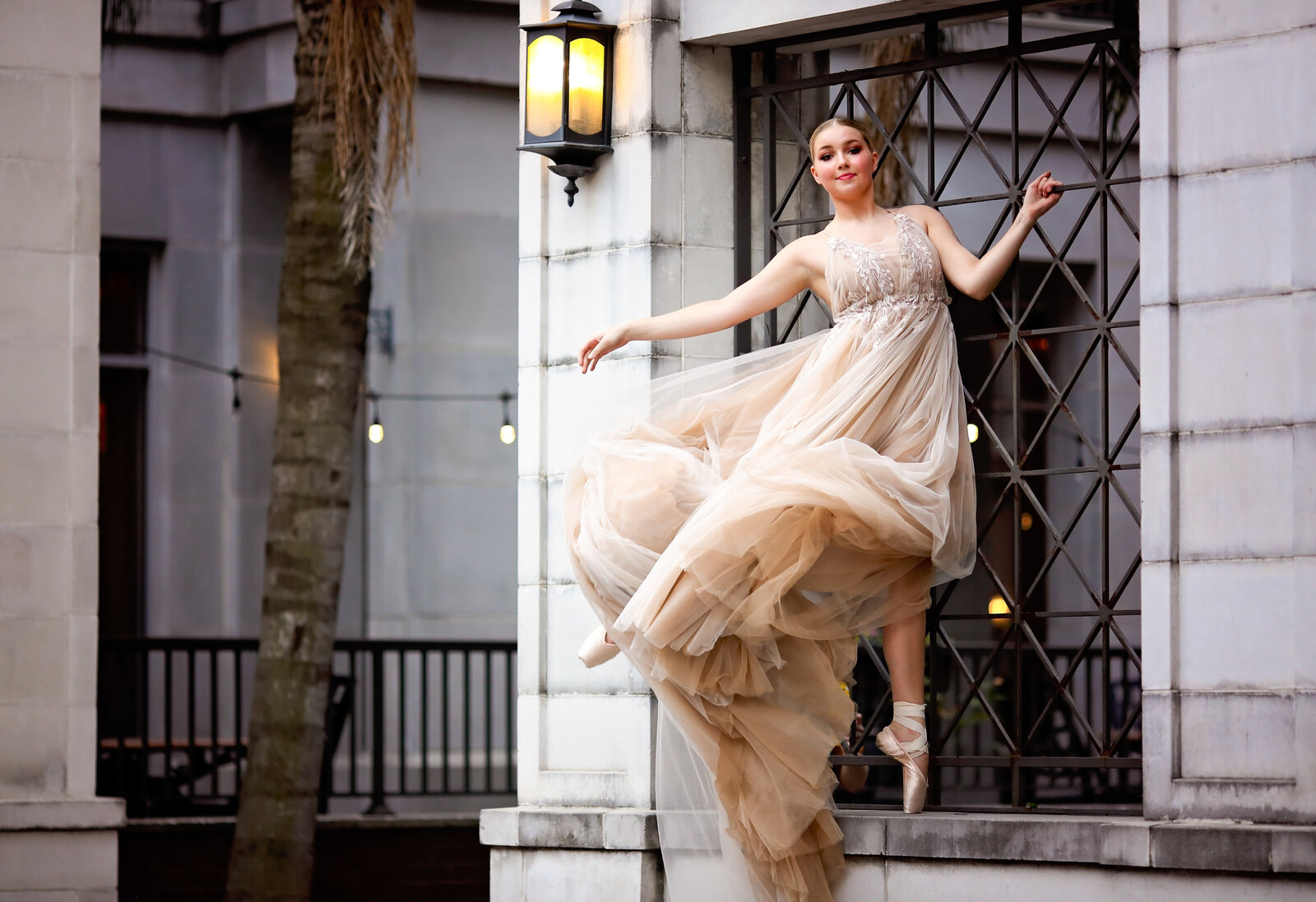 Savannah Boudoir Photography and Glamour showcases gorgeous blond dancer in flowing glamour gown on pointe in window