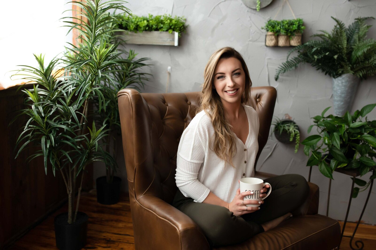 woman in formal attire sitting on a couch and holding a mug