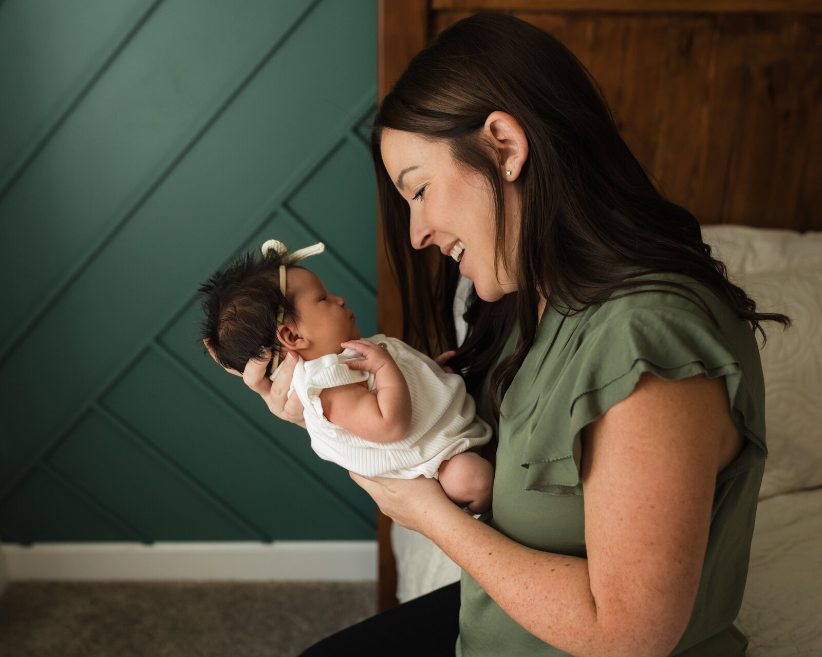 mom holding newborn baby girl for in home lifestyle newborn session 