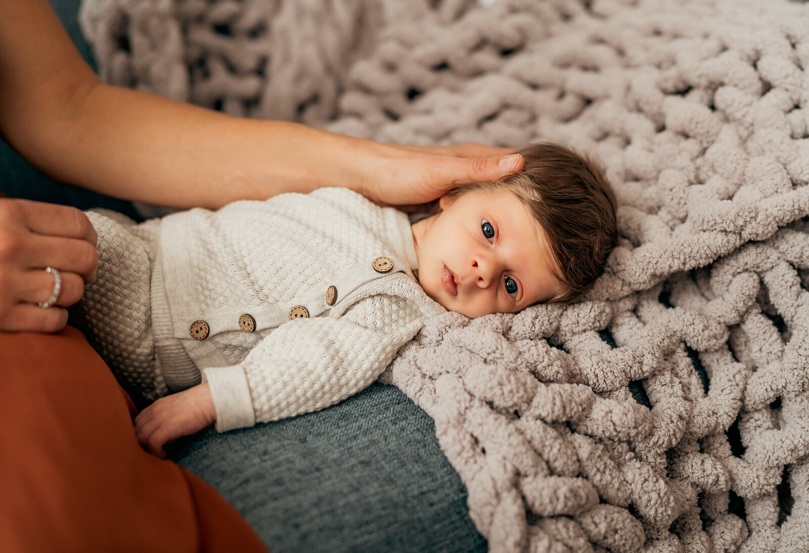 baby boy laying on a bed during a newborn session in st. louis