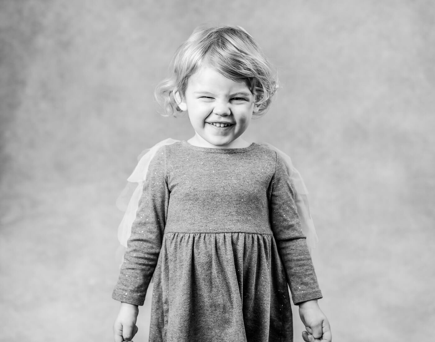 A child poses in front of the camera, smiling.