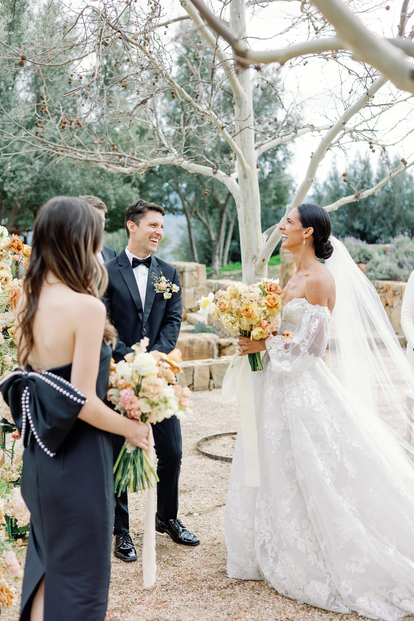 outdoor wedding ceremony with bride and groom laughing together as they meet at the end of the aisle at their outdoor California wedding venue captured by wedding photographer bay area