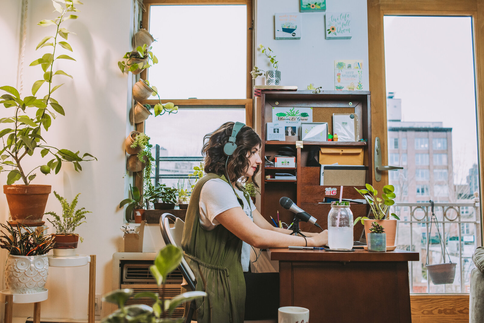 Maria Failla, founder of the Growing Joy with Plants podcast, standing in front of her plant collection