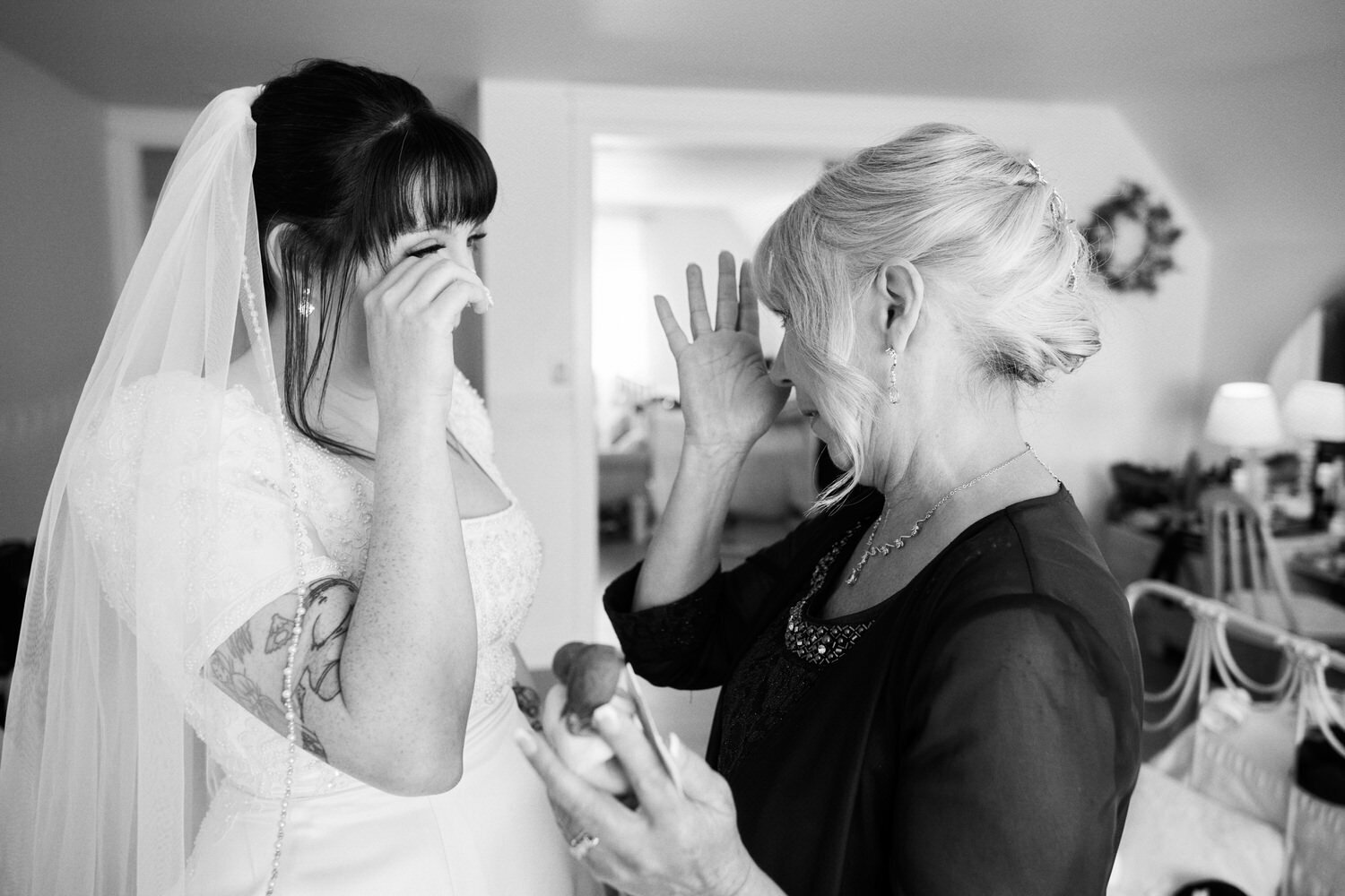Bride and her mother wipe away tears.