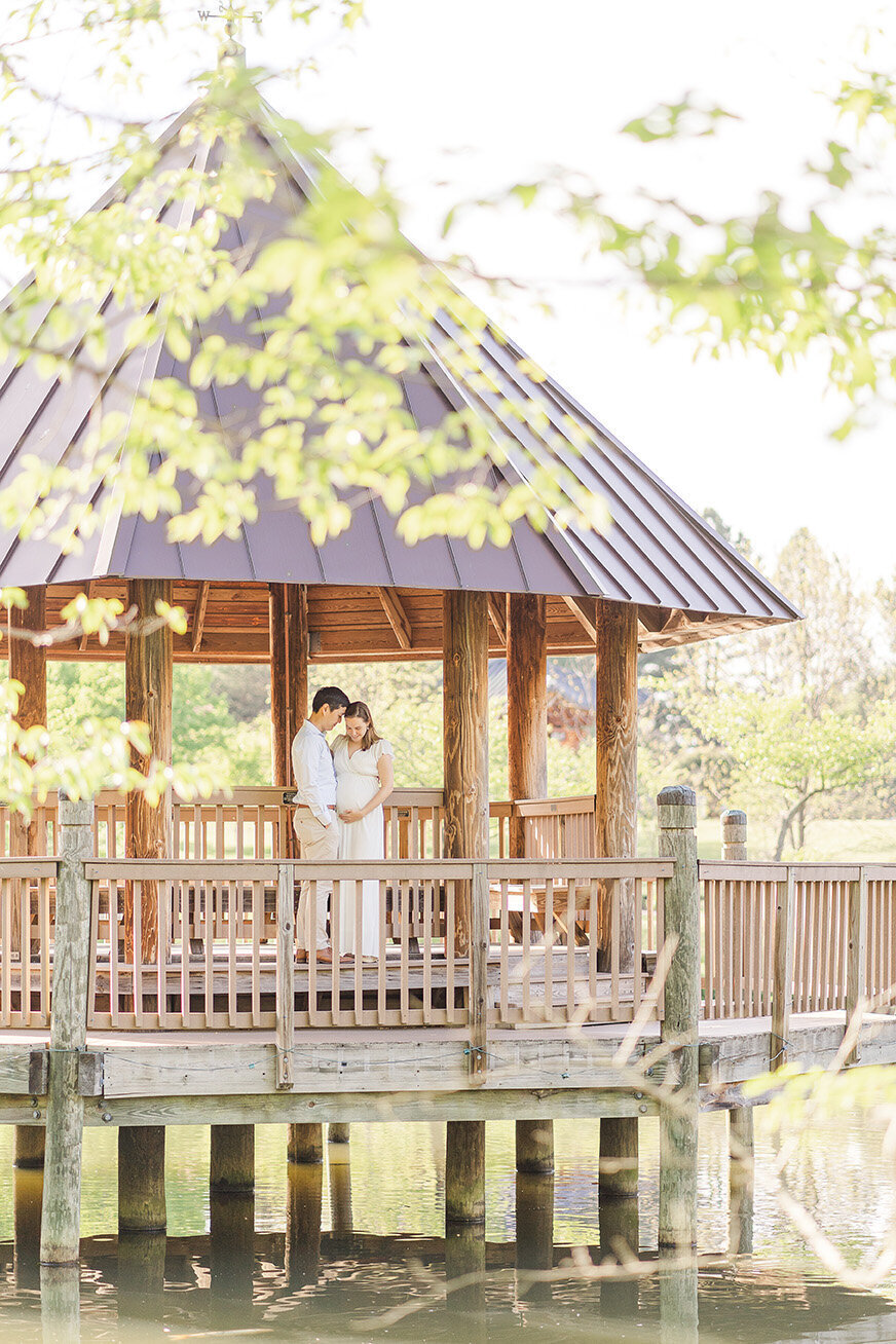 expecting couple in a gazebo during maternity photo in Alexandria, VA