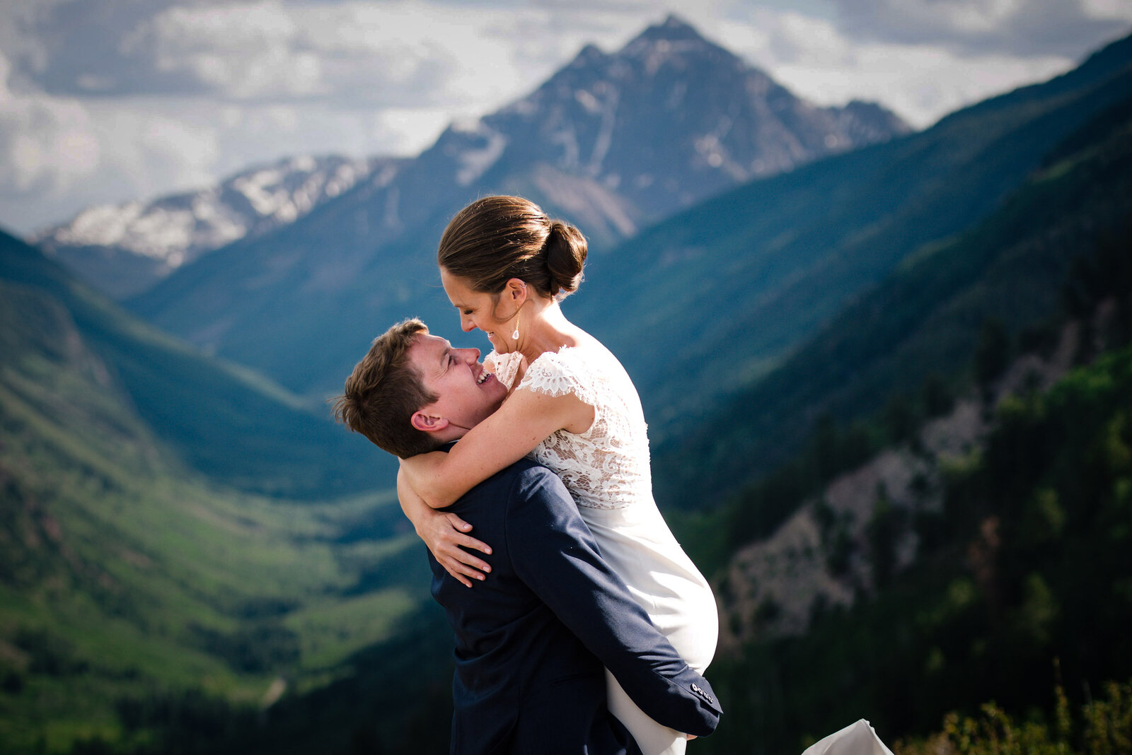 Groom picking up Bride in Front of Mountain