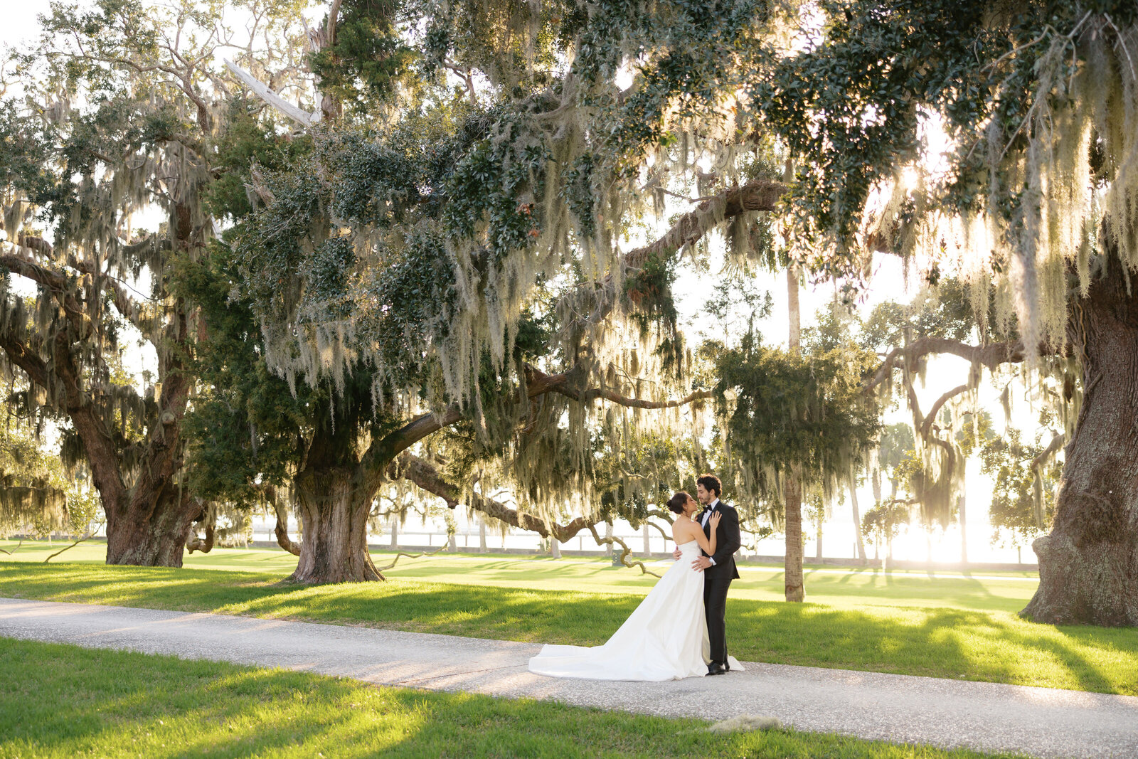 jekyll island wedding sunset photo with spanish moss trees surrounding bride and groom in their formal attires hellencophotos