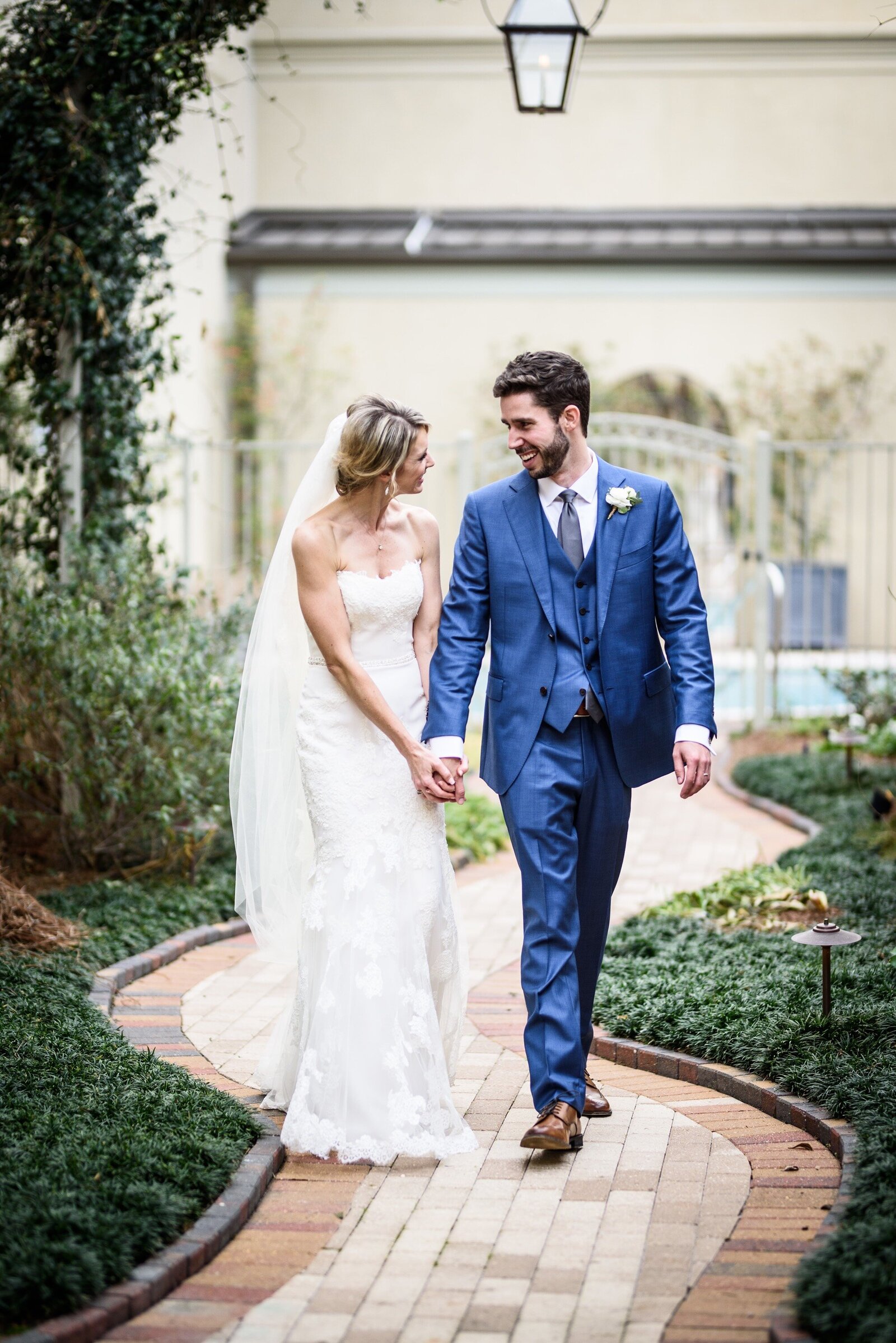 Bride and groom walking down brick pathway at Southern Hotel wedding in Covington Louisiana