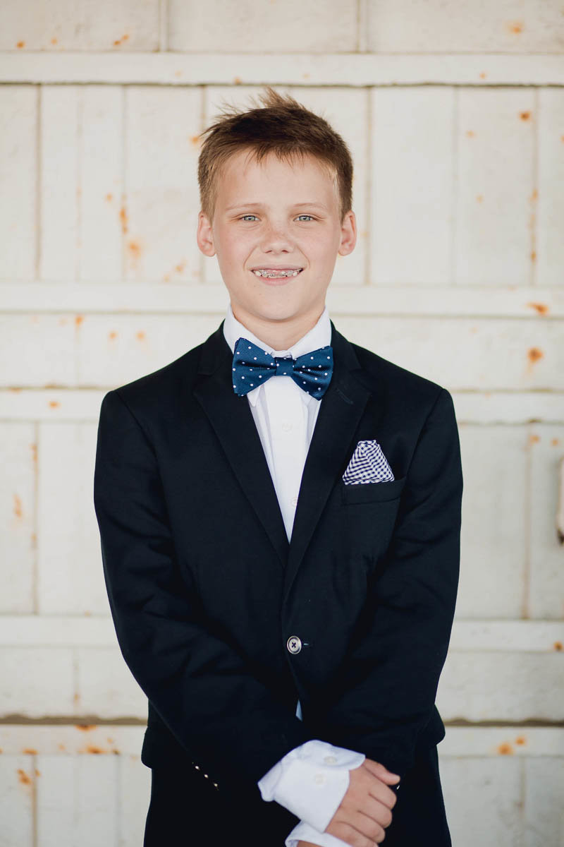 Ringbearer stands in front of large ship door, USS Yorktown, Patriots Point, Charleston, South Carolina. Kate Timbers Photography.