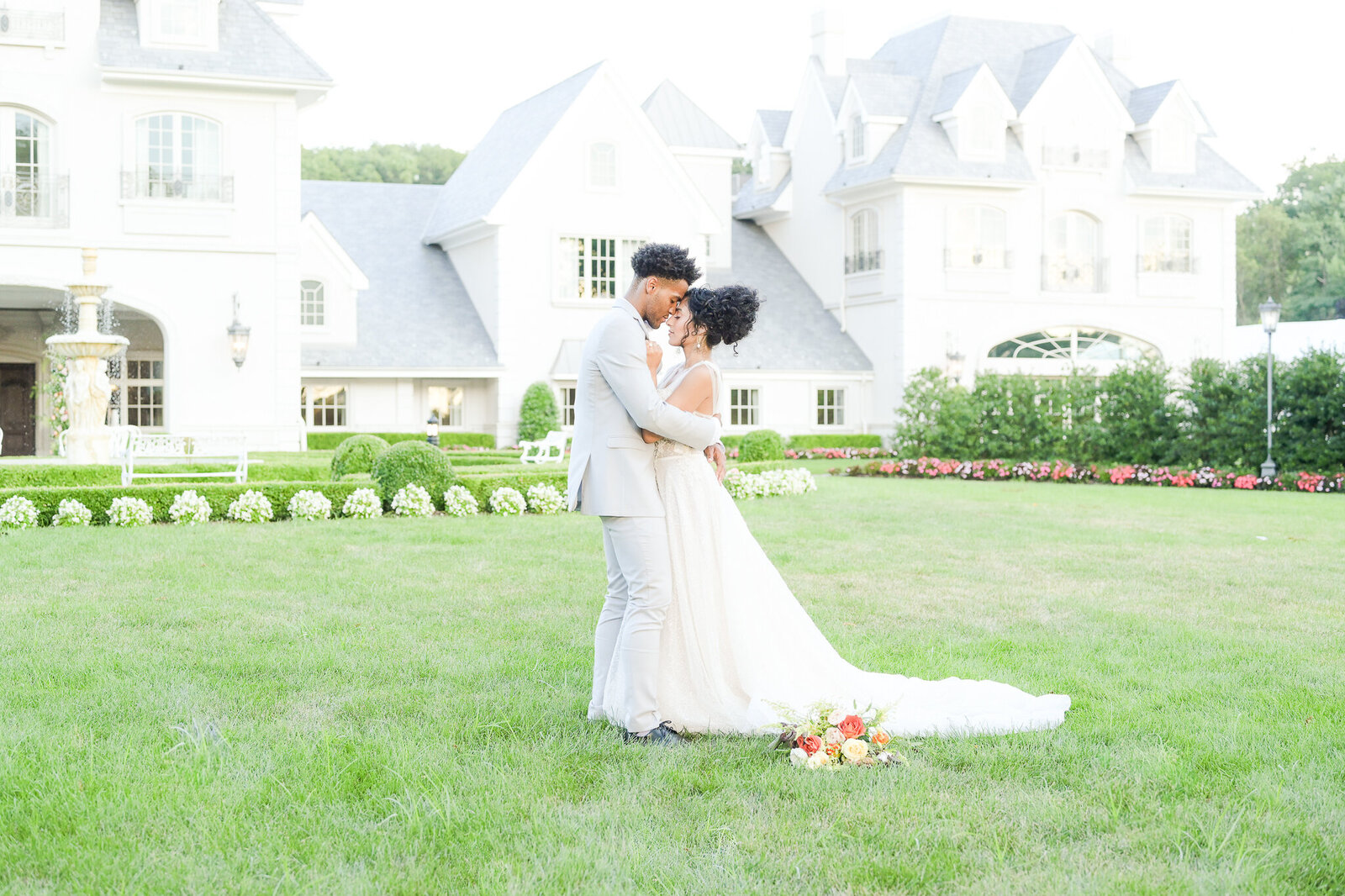 Gorgeous bride stands with her groom  in front of The Park Chateau
