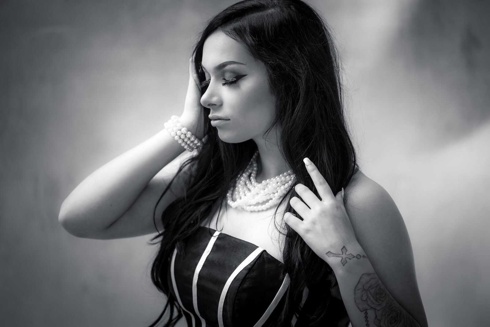 black and white close up of a brunette senior girl with pearls and black and white dress
