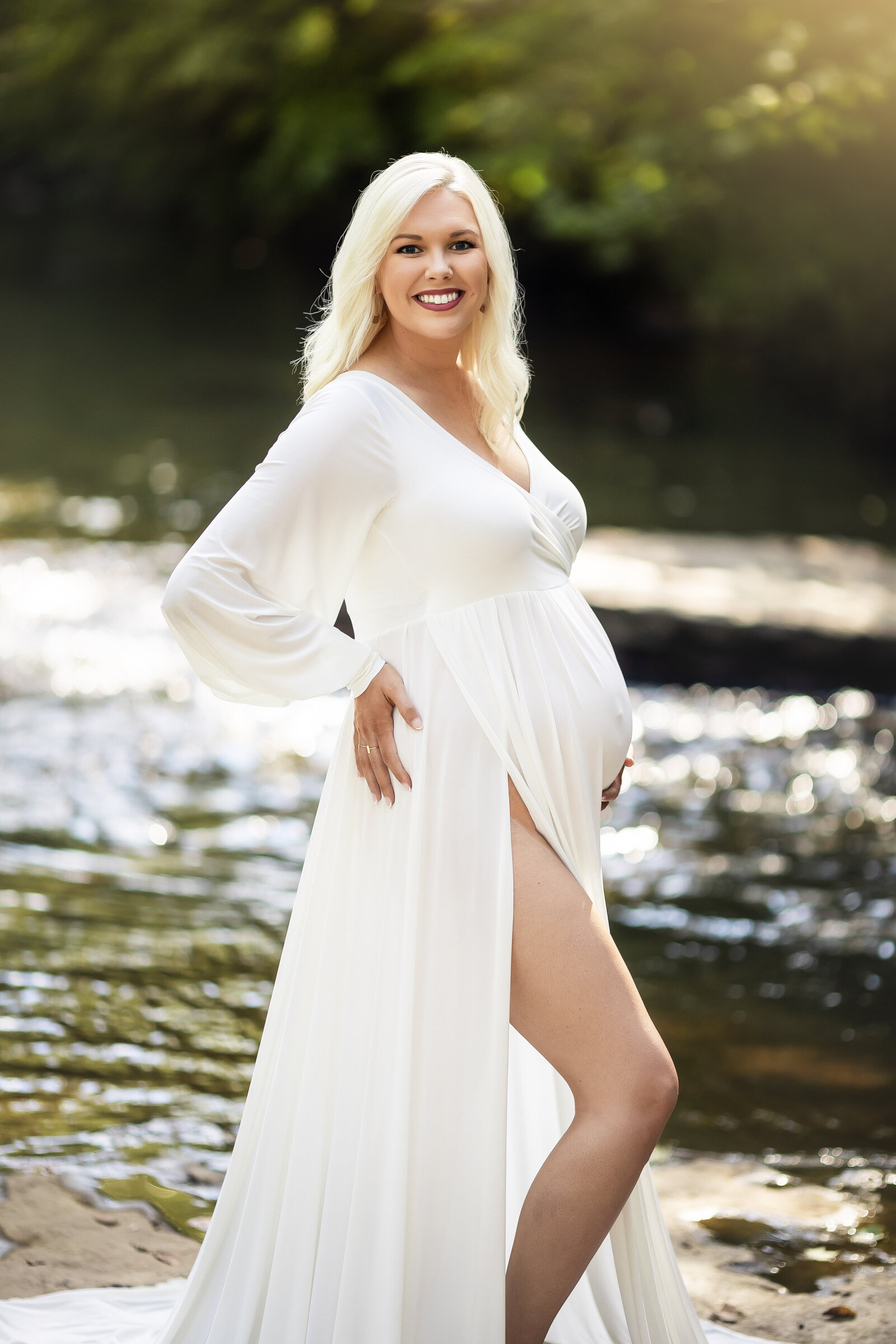 Beautiful mother poses in a creek  for a maternity session near Birmingham
