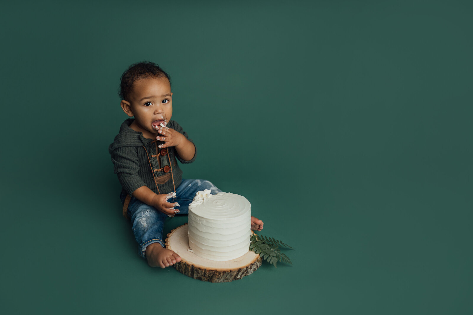 boy eating white cake at photography studio in Tampa
