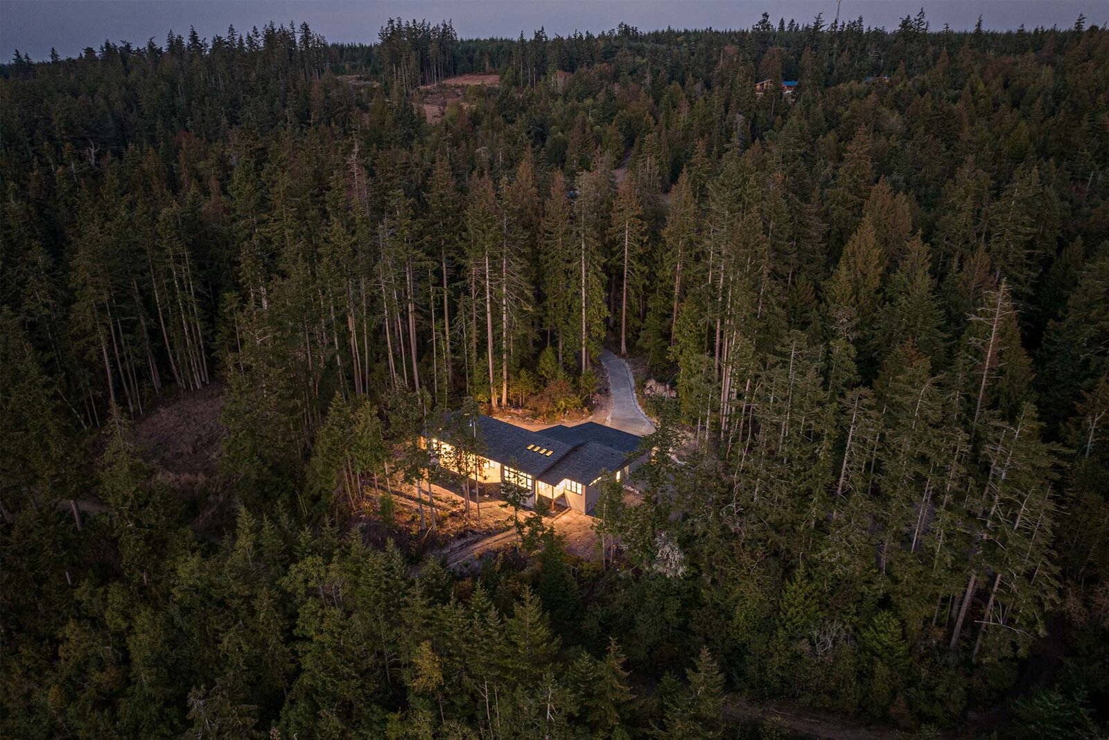 Livingston-Homes-Kelowna-Custom-Build-LaPlume-exterior-twilight-aerial-forest