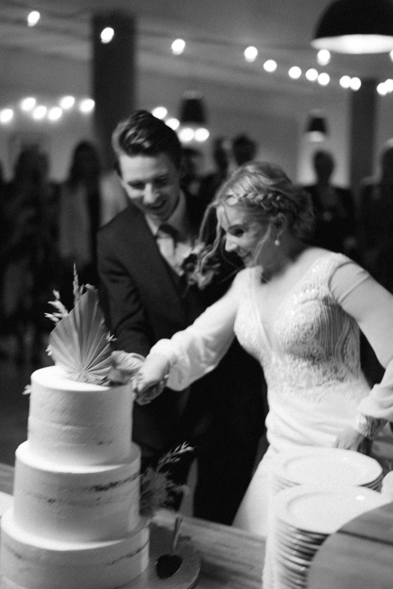 A documentary wedding  photo of the couple cutting the cake in Oitbacka gård captured by wedding photographer Hannika Gabrielsson in Finland