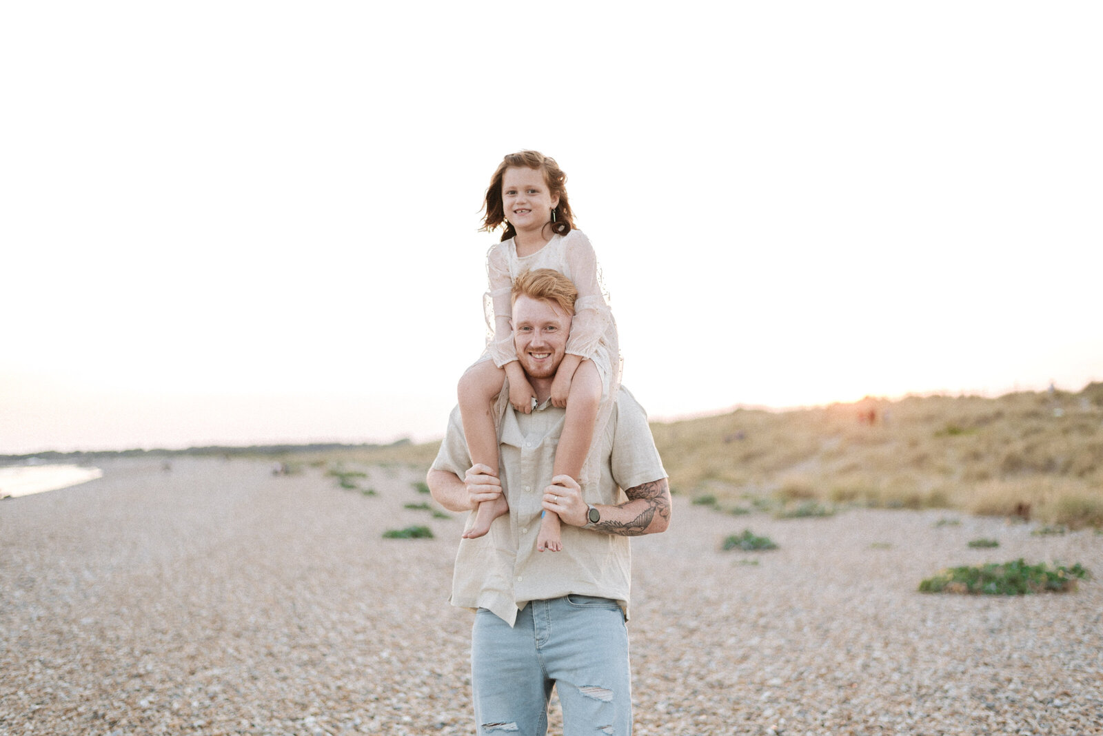 Dad holding his daughter on his shoulders during a family photoshoot in Billingshurst