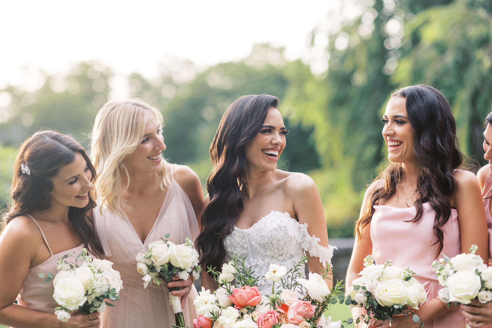 Bride smiles with her bridesmaids on her wedding day.