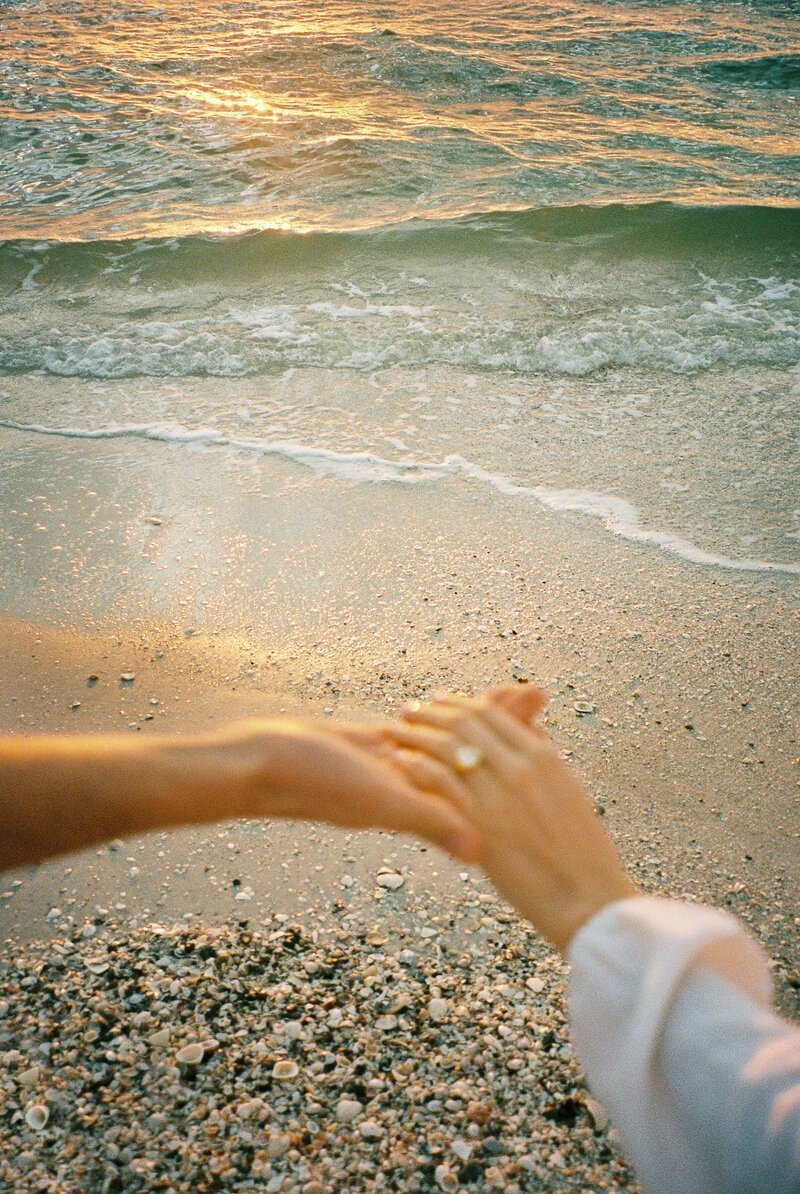 couple holding hands on beach, taken by beach photographer naples fl
