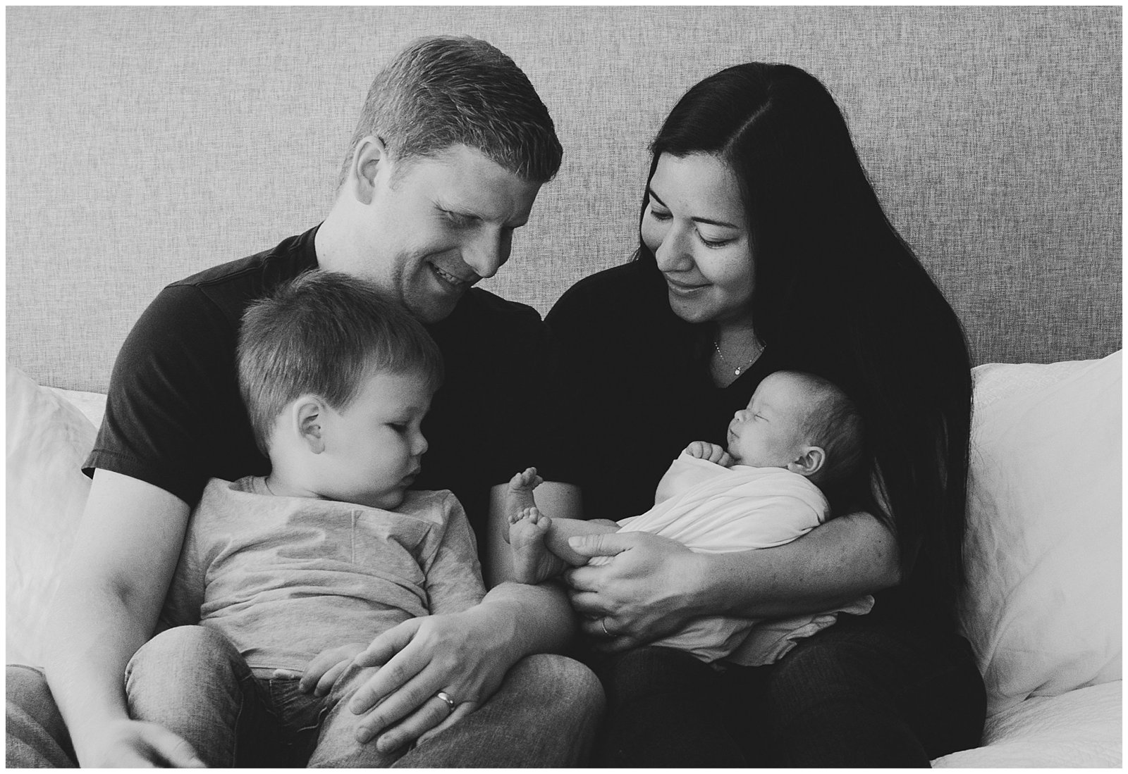 Newborn baby girl with family on bed in black and white Emily Ann Photography Seattle Photographer